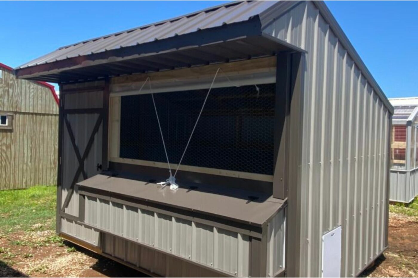 Close view of a chicken coop wall with high ventilation openings covered by hardware cloth, showing good airflow design above roost height